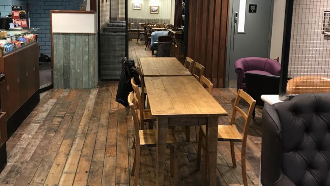 Wooden tables and chairs set out in a refurbished cafe